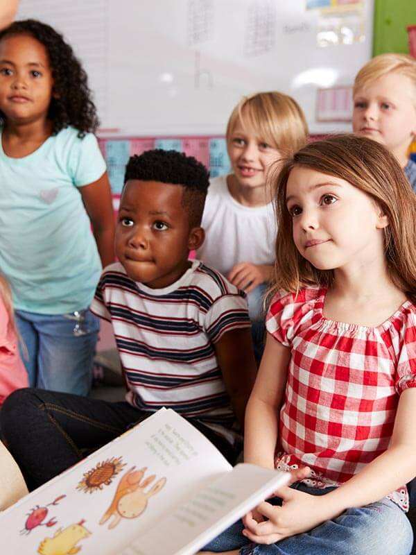A woman reads to a classroom of children