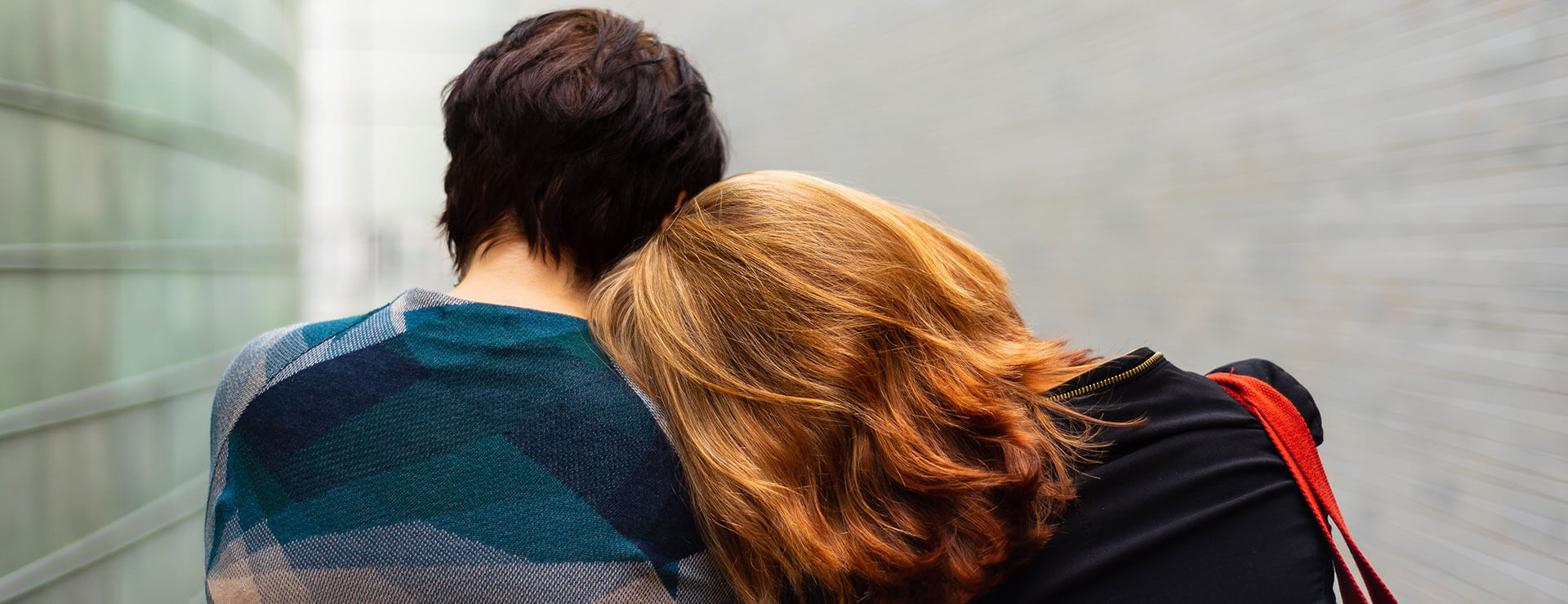 A woman rests her head on a man's shoulder.