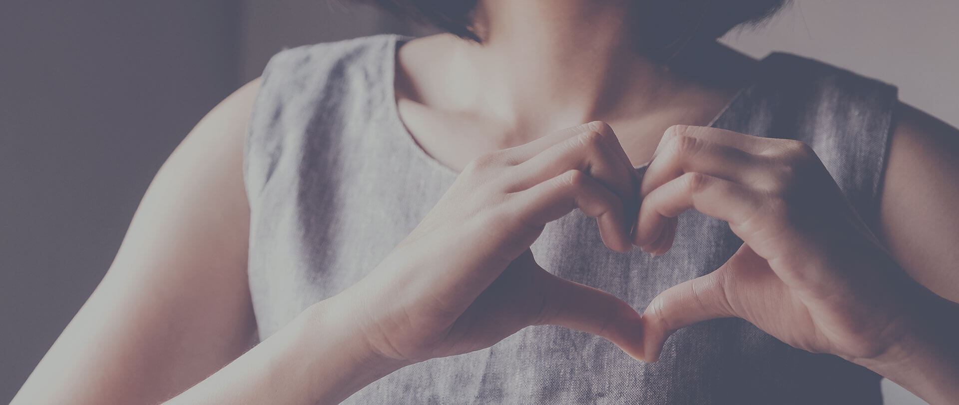 A woman doing that heart thing with her hands