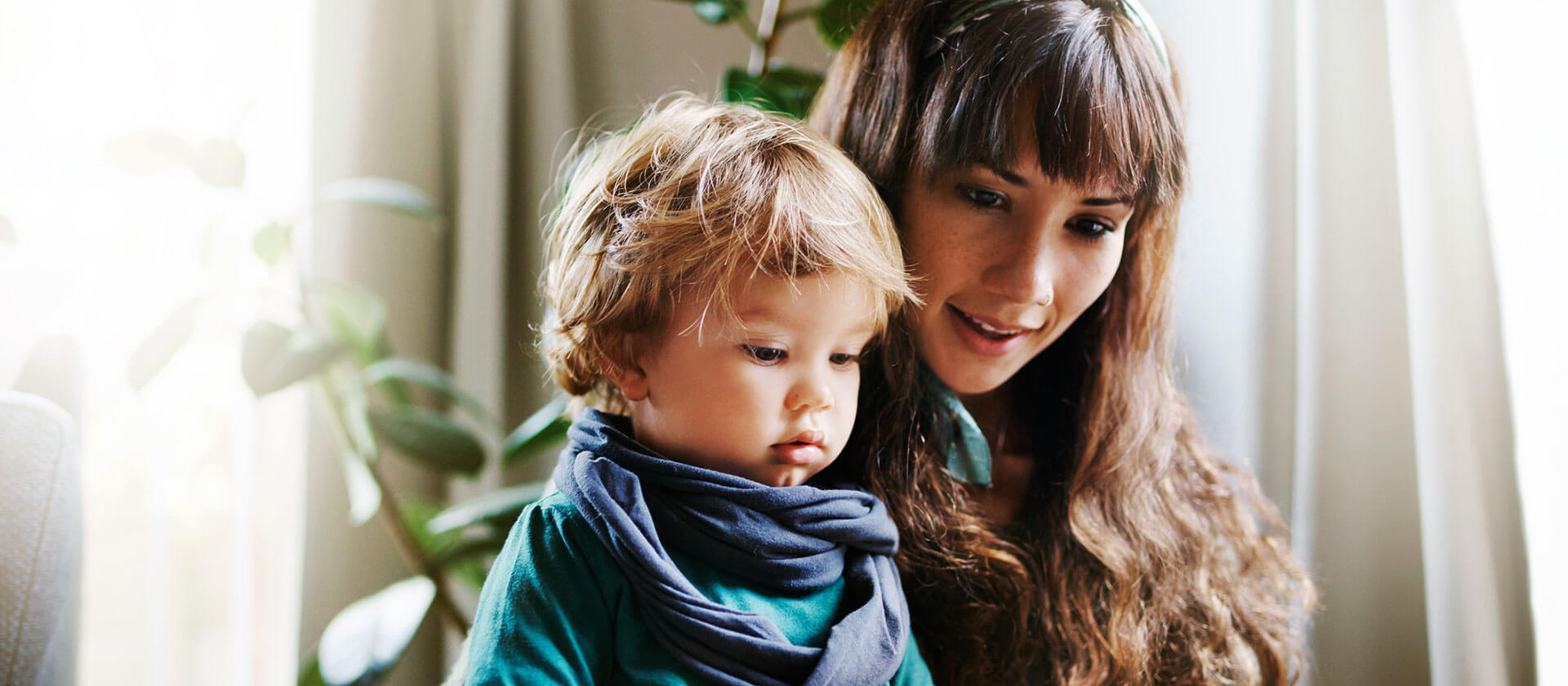 A young woman reads to a baby